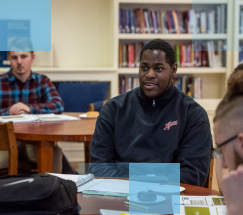 Estudiante de secundaria afroamericano sentado en una mesa en la biblioteca