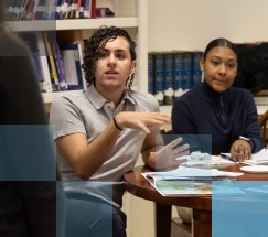 Grupo diverso de estudiantes conversando en una mesa en una biblioteca