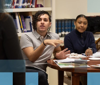 Grupo diverso de estudiantes conversando en una mesa en una biblioteca