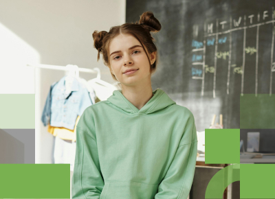 A confident female high school student standing in front of a chalk board