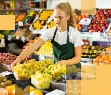 A female high school graduate working in the produce section of a market