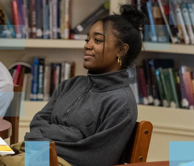 Estudiante afroamericana sentada en una mesa en una biblioteca
